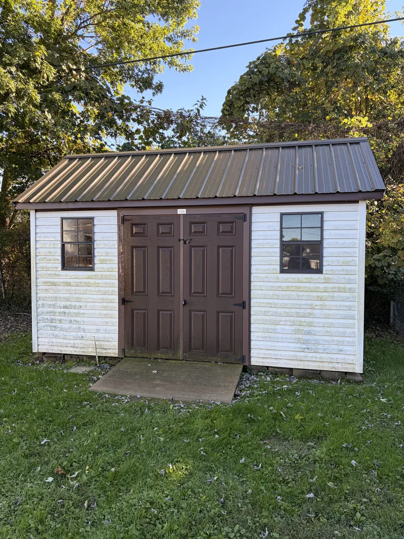Before: shed with algae-stained vinyl siding
