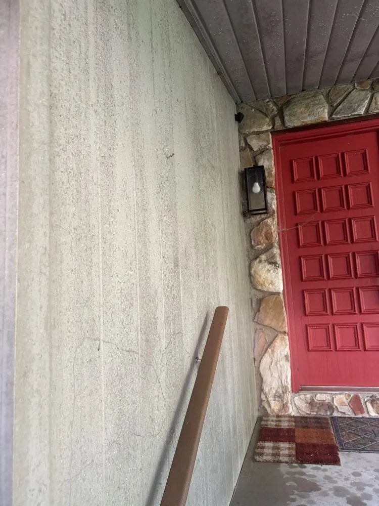 Before: wood siding at the front entry covered in grime